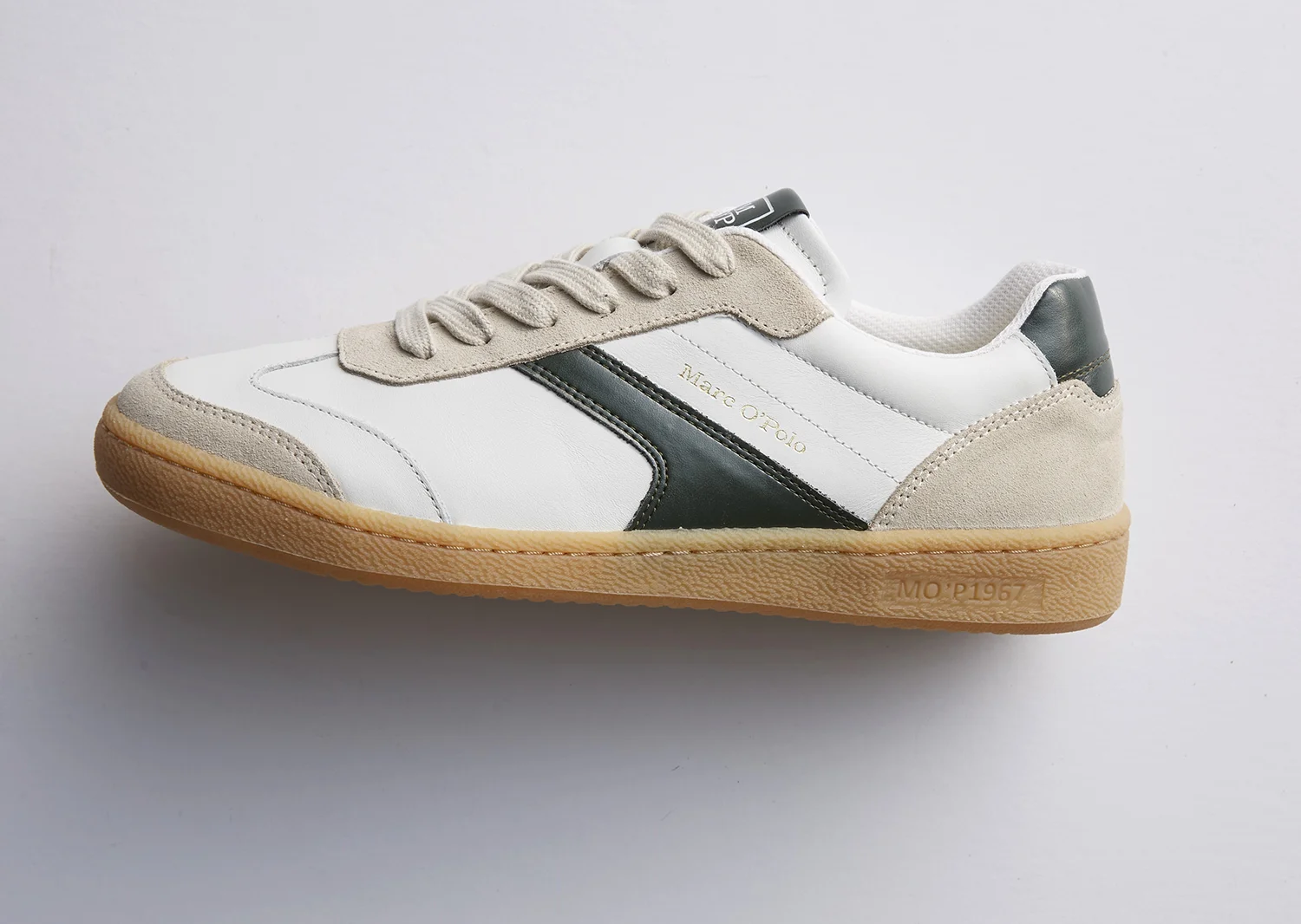 Weißer Sneaker mit grauen Wildlederdetails, schwarzem Seitenstreifen und hellbrauner Gummisohle, seitlich mit Schriftzug 'Marc O'Polo'.