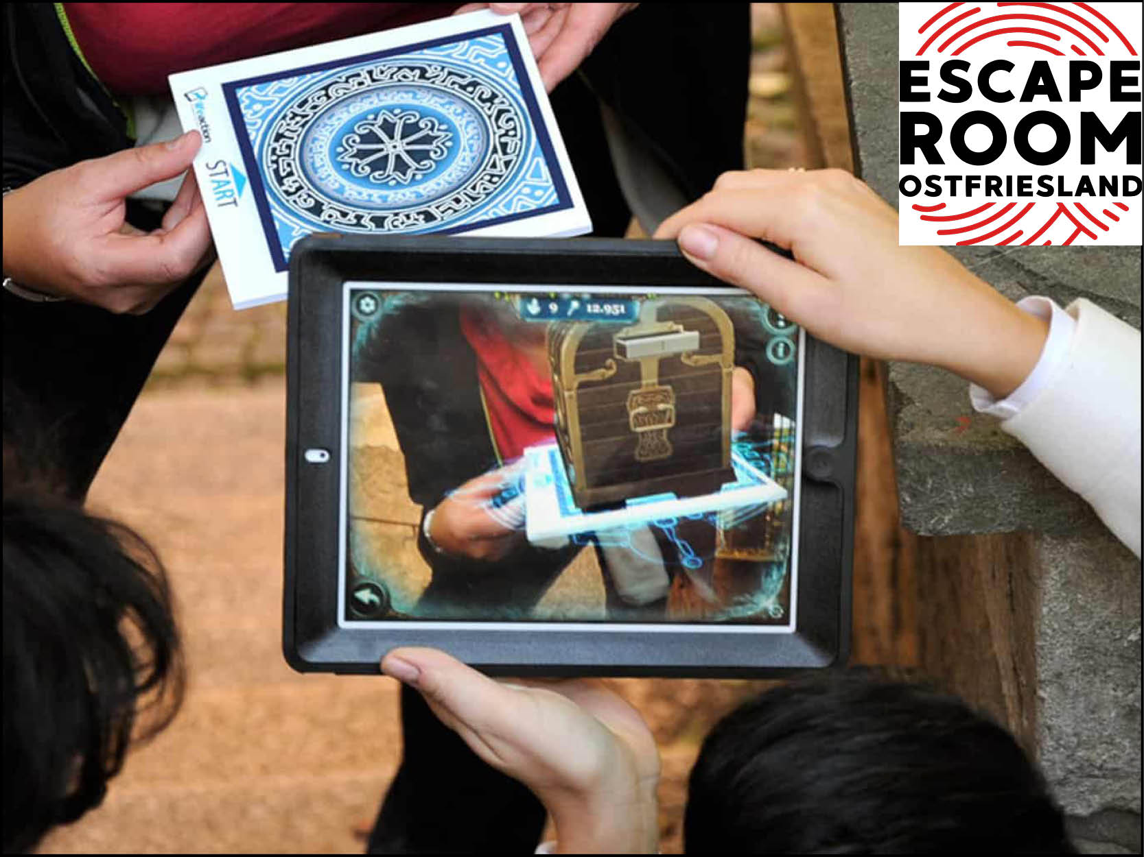 Eine Gruppe hält ein Tablet, während Sie ein Outdoor Escape Game spielen